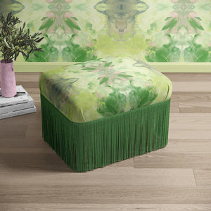 Amalfi Eco Velvet velvet by Liberty James Studio in green and pink, a marbled kaleidoscope design covering a footstool