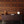 Beau Burr wallpaper by Liberty James Studio in brown and orange, a burr wood grain design above a sideboard