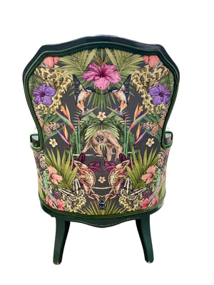 Exotica velvet by Victoria Sanders in black, jungle animals and tropical flowers covering an armchair