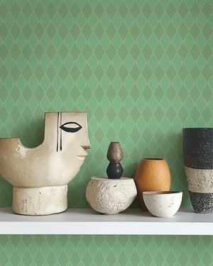 Harlequin Parade wallpaper by Annika Reed in green, a small harlequin check above a sideboard