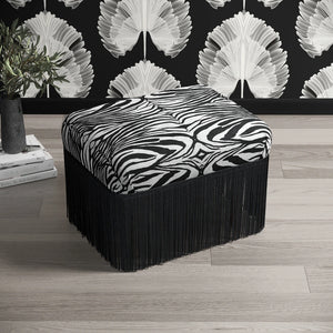 Zulu Zebra Eco velvet by Liberty James Studio in black and white, zebra stripes upholstered on a fringed footstool