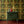 Gilded Wine wallpaper by Liberty James Studio in gold, green and red, an ornate mirrored design above a sideboard