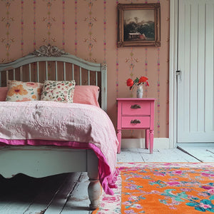 Angels and Suns wallpaper by Tatie Lou in pink, cherubs and suns in trails in a bedroom