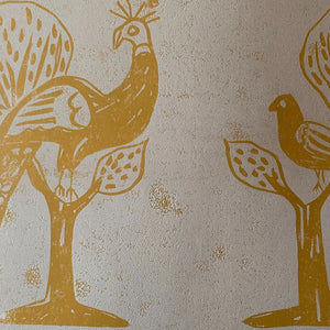 A Jackdaw and Peacock Feathers wallpaper by Annika Reed in orange and green, detail of birds and stylised trees
