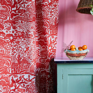 All Tomorrow’s Future linen by The Monkey Puzzle Tree in red, a dense folk-art scene in a kitchen