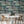 Animal Islands wallpaper by Brand McKenzie in navy, palm-filled islands and wildlife behind a dining table