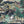 Animal Islands wallpaper by Brand McKenzie in navy, close view of palm-filled islands and wildlife