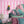 Scallop Lane wallpaper by Liberty James Studio in pink, scalloped stripes behind a bed