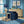 Bel Harbour wallpaper by Liberty James Studio in blue, varied stripes behind a sofa in a living room