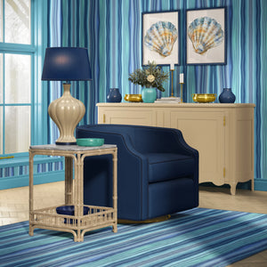 Bel Harbour wallpaper by Liberty James Studio in blue, varied stripes behind a sofa in a living room