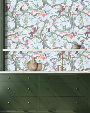 Balancing Act wallpaper by Brand McKenzie in mint green and pink, monkeys, toucans and flamingos in vines above a cabinet