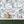 Balancing Act wallpaper by Brand McKenzie in mint green and pink behind a console table