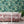 Banana Leaves Max wallpaper by Brand McKenzie in pink, large banana leaves behind a sofa in a living room