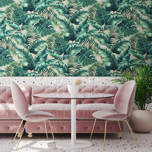 Banana Leaves Max wallpaper by Brand McKenzie in pink, large banana leaves behind a sofa in a living room