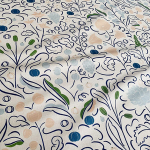 Beatrice linen by Claire de Quénetain in blue, draped, showing a hand-painted floral design