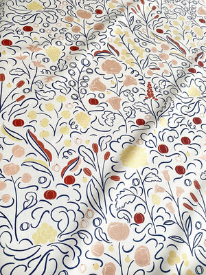 Beatrice linen by Claire de Quénetain in red, in soft folds showing a hand-painted floral design