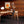 Beau Burr wallpaper by Liberty James Studio in brown and orange, a burr wood grain design behind a desk in a home office