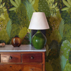 Savana wallpaper by Deus ex Gardenia in green, large savanna leaves above a sideboard