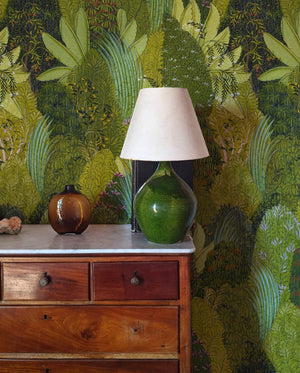 Savana wallpaper by Deus ex Gardenia in green, large savanna leaves above a sideboard