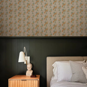 A Jackdaw and Peacock Feathers wallpaper by Annika Reed in orange and green, birds and stylised trees in a bedroom