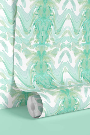 Bel Air Blossom wallpaper by Liberty James Studio in mint green, partly unrolled roll showing a mirrored blossom design
