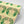 Boucle wallpaper by Tatie Lou in yellow, partly unrolled roll showing bold retro rings
