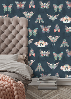Butterfly Effect wallpaper by Brand McKenzie in navy, butterflies and moths behind a bed