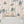 Carousel wallpaper by Brand McKenzie in cream, carousel animals on poles above a white mantelpiece