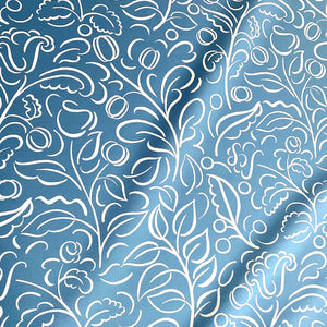 Celeste linen by Claire de Quénetain in blue, draped, showing swirling leaf scrolls