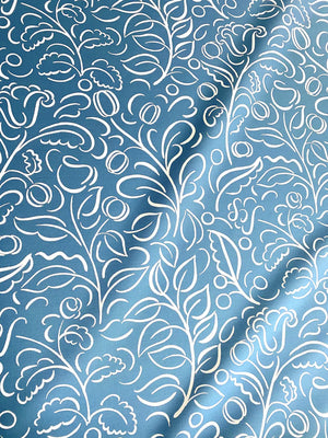 Celeste linen by Claire de Quénetain in blue, draped, showing swirling leaf scrolls