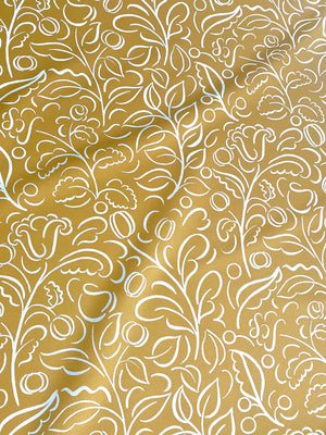 Celeste linen by Claire de Quénetain in yellow, draped close-up of swirling leaf scrolls