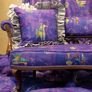 Celestial Promenade linen by The Monkey Puzzle Tree in purple, celestial figures upholstered on an armchair