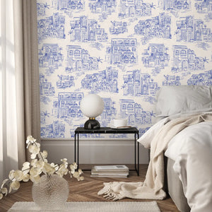 Charming Lanes wallpaper by Brand McKenzie in blue, toile-style townhouses in a bedroom