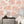 Charming Lanes wallpaper by Brand McKenzie in orange, toile-style townhouses behind a bed