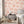 Charming Lanes wallpaper by Brand McKenzie in orange, toile-style townhouses in a bedroom