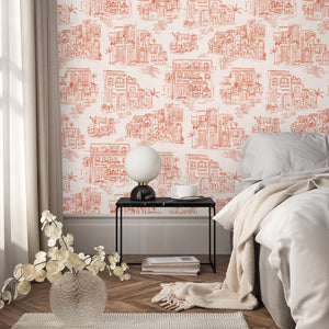 Charming Lanes wallpaper by Brand McKenzie in orange, toile-style townhouses in a bedroom