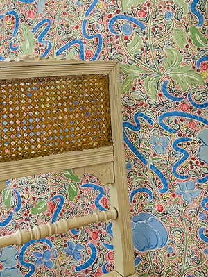 Axelle wallpaper by Claire de Quénetain in green and blue, a hand-painted floral design in a styled room setting