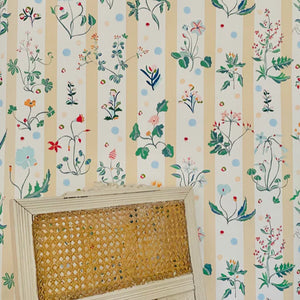 Caroline wallpaper by Claire de Quénetain in yellow and green, a hand-painted floral design in a styled room setting