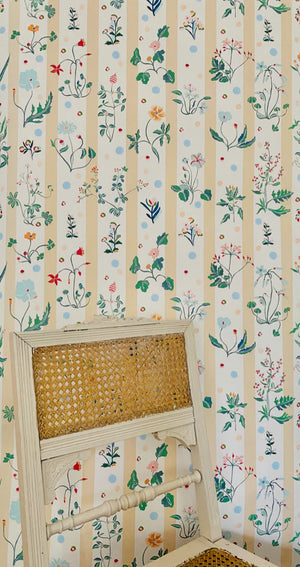 Caroline wallpaper by Claire de Quénetain in yellow and green, a hand-painted floral design in a styled room setting