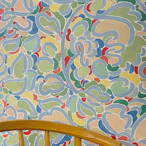 Charlotte wallpaper by Claire de Quénetain in pink and green, a hand-painted floral design in a styled room setting
