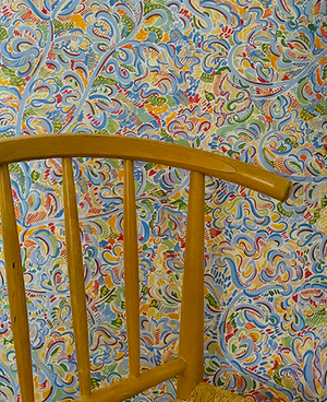 Felicity wallpaper by Claire de Quénetain in green and yellow, a hand-painted floral design in a styled room setting