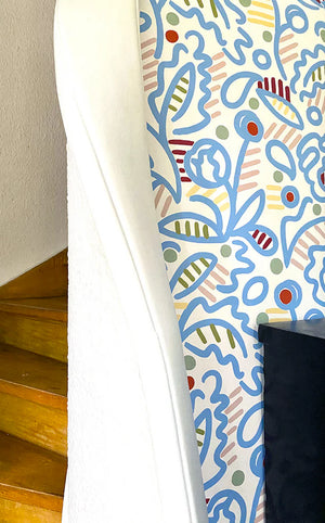 Julius wallpaper by Claire de Quénetain in blue, a hand-painted floral design in a styled room setting