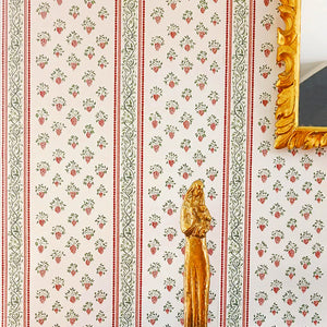 Clarisse wallpaper by Claire de Quénetain in green and red, floral stripes above a sideboard