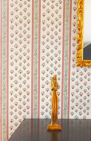 Clarisse wallpaper by Claire de Quénetain in green and red, floral stripes above a sideboard