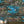 Club Safari wallpaper by Brand McKenzie in turquoise, a lush safari scene on a living room wall