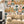 Connecting Frames wallpaper by Brand McKenzie in caramel, a gallery wall of framed portraits on a living room wall