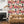 Connecting Frames wallpaper by Brand McKenzie in pink, a gallery wall of framed portraits on a living room wall