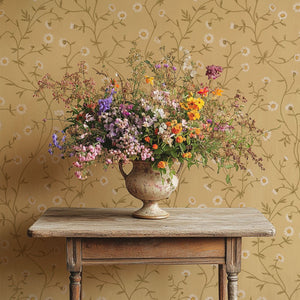 Daisy Chain wallpaper by Studio Le Cocq in yellow, trailing daisy chains above a sideboard