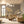 Dancing Flowers wallpaper by Dami and Em Design in beige, large dancing flowers behind a sofa in a living room