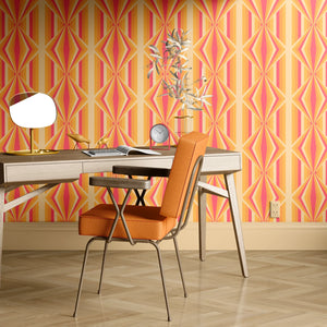 Deco Prism wallpaper by Liberty James Studio in orange, art deco wave stripes behind a desk in a home office